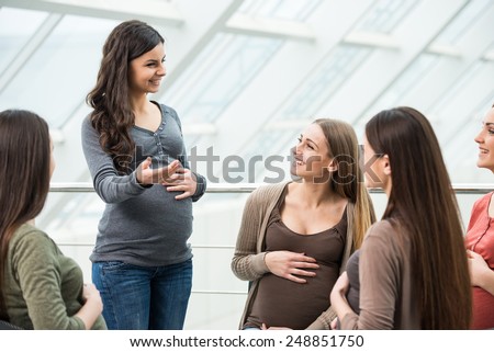 Happy pregnant women are talking together at antenatal class at the hospital.