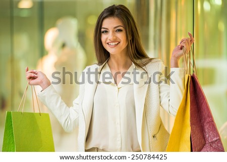 Happy woman with shopping bags in shopping mall is looking at the camera. Sales. Shopping Center.