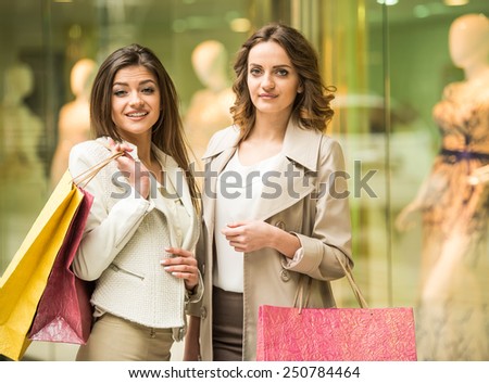 Two happy friends with shopping bag is shopping in mall and looking at the camera.