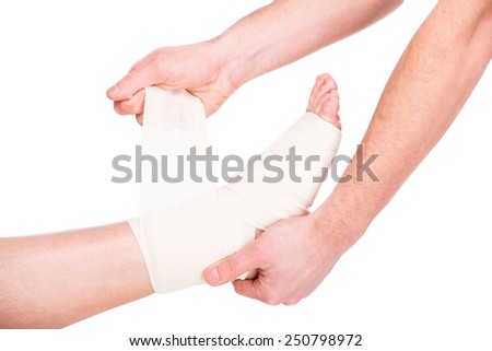 Close-up man is putting bandage on injured feet.