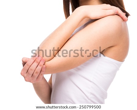 Acute pain in a woman elbow. Female is holding hand to spot of elbow pain indicating location of the pain. Isolation on a white background.