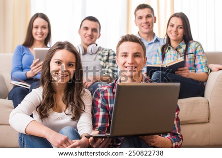 Education and people concept. Group of students with laptop, are looking at the camera while sitting in room.