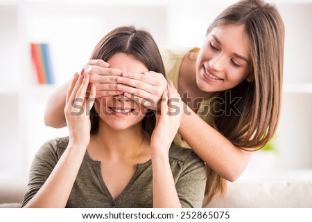Smiling teen daughter closes eyes to her mom.