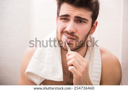 Morning routine of washing the teeth. Handsome young man is brushing teeth with toothbrush.