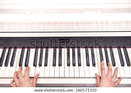 Women hands are playing the piano. Close-up.