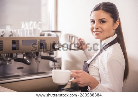 Smiling female barista is preparing coffee at coffee shop.