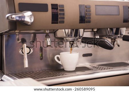 Close-up of an espresso machine making a cup of coffee.