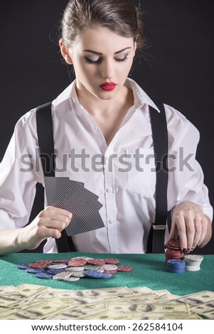 Beautiful and dangerous. Young female gangster play poker. isolated on dark background.