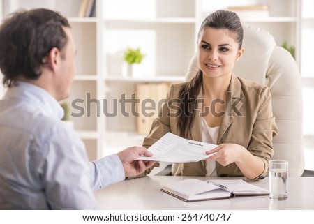 Businesswoman interviewing male candidate for job in office.