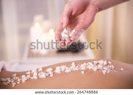 Close-up. Female getting a salt scrub beauty treatment in the health spa.