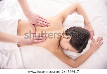 Top view. Spa therapy. Beautiful asian woman having massage in beauty salon.