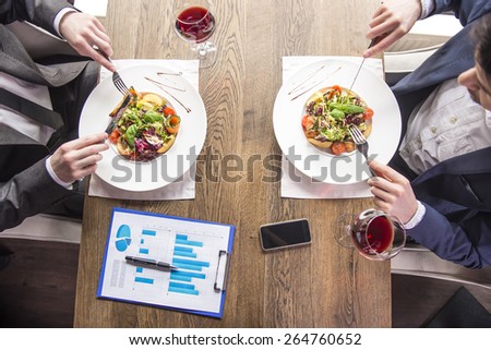 Close-up. Top view. Businessmen eating during a business lunch in restaurant.