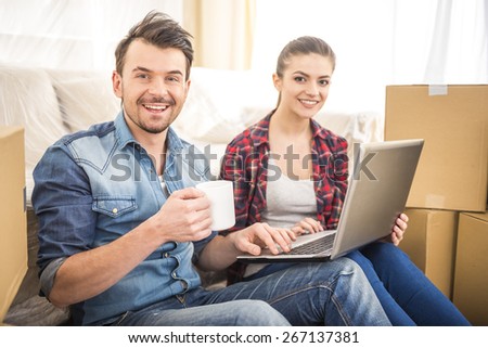 The young happy couple searching for apartments with laptop. Moving, purchase of new habitation.