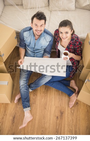 The young happy couple planning a new house. Moving, purchase of new habitation.