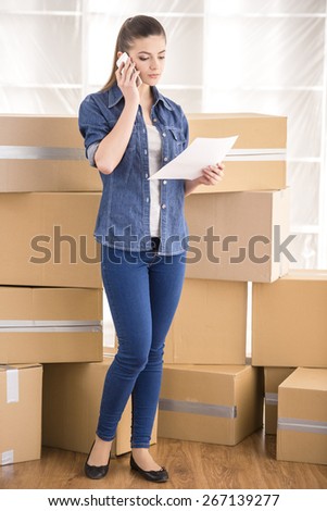 The young happy woman calling transport company to move in new house.