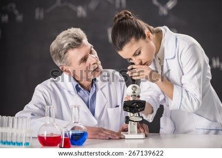 Senior chemistry professor and his assistant working  in  laboratory.