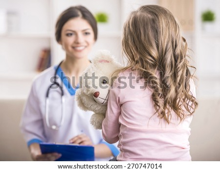 Young smiling female doctor and her little patient  with teddy bear.