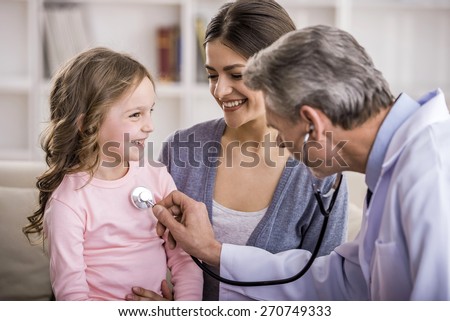 Pediatrician checks breath stethoscope a little girl in the arms of mother.