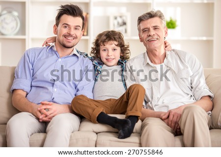 Generation portrait. Grandfather, father and son sitting on sofa.