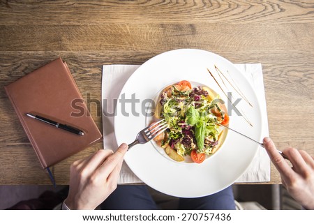 Close-up. Top view. Businessman eating during a business lunch in restaurant.
