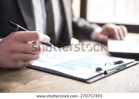 Close-up. Businessman working with notebook and dokument in restaurant.