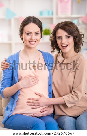Woman is visiting pregnant friend at home.