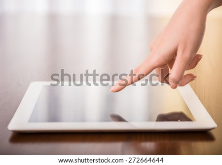 Female hand presses on screen digital tablet.