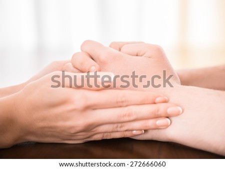 A couple holding hands on the table.