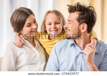 Portrait of happy young parents with their kid girl.