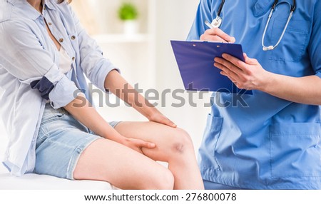 Close-up of male doctor with stethoscope examining female patient at doctor\'s office.