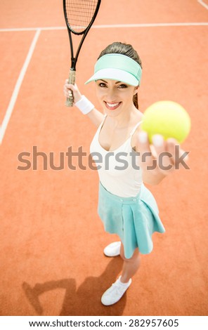 Woman in sportswear serves tennis ball. Tournament.