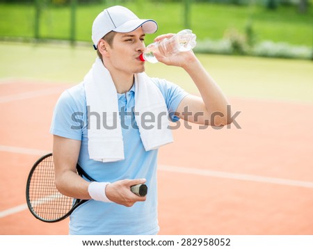 Young sporty man play tennis at court outdoors. Healthy lifestyle concept.