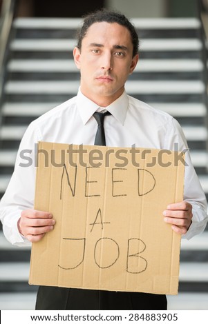 Man in suit holding sign in hands. Unemployed man looking for job.