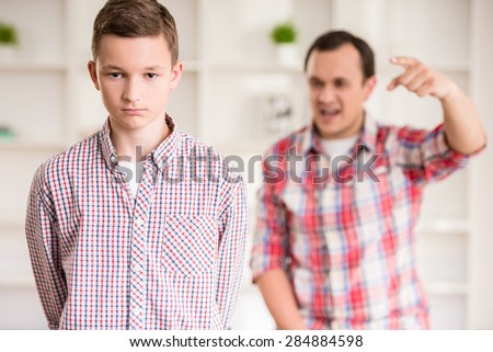 Father and son dressed casual having quarrel at home.