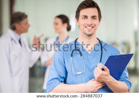 Young male doctor with colleagues at doctor\'s office.