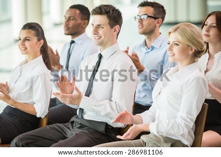 Happy business group of people clapping hands during a meeting conference.