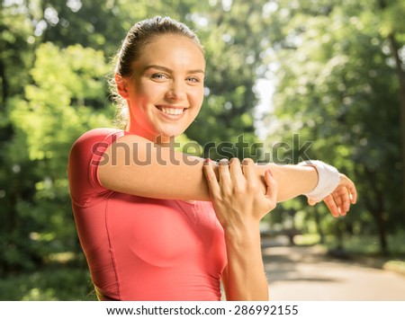 Young athletic girl doing physical exercises in the park at sunrise.
