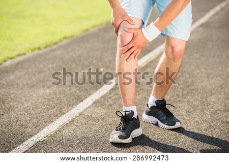 Close-up of young sporty man prepares to run sprint.