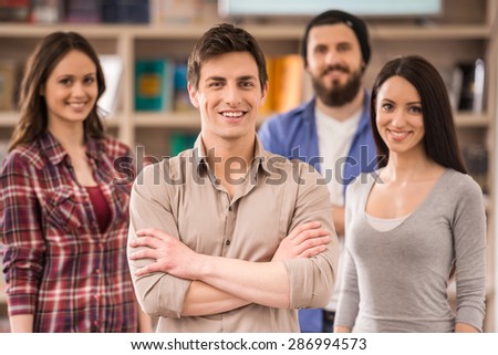 Creative group of designers dressed casual looking at camera and smiling.