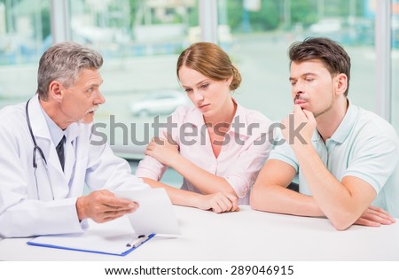 Family couple sitting in doctor\'s office at consultation.