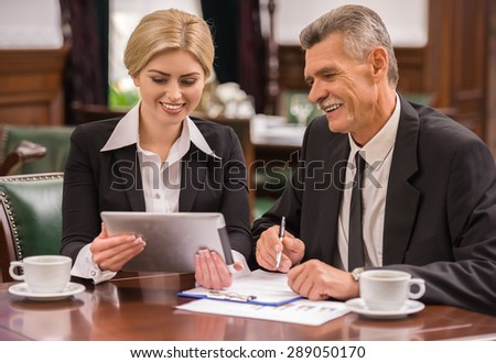 Two business partners using digital tablet during business meeting.