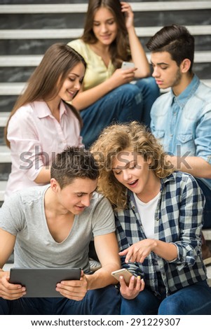 College friends watching pics on phone at break.
