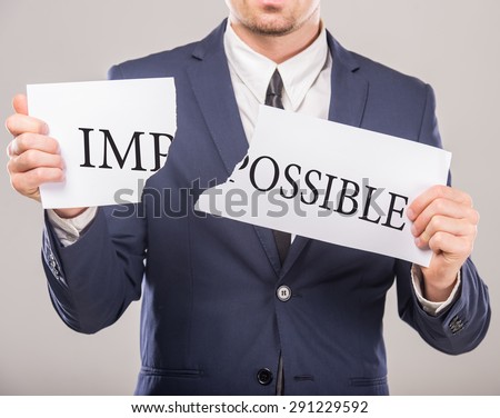 Business man holding paper fragments with message text written on it. Close-up.