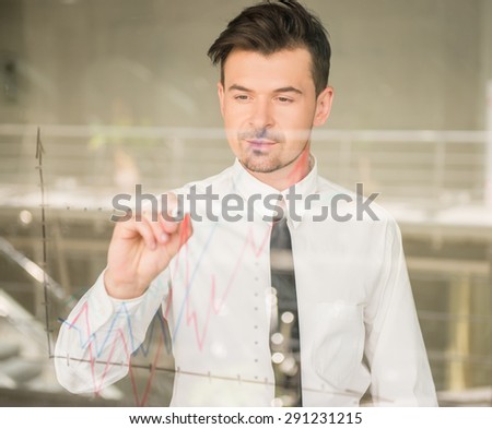 Confident business man dressed formal drawing business strategy on  window at office.