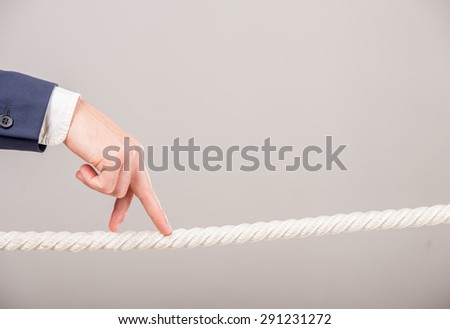 Close-up of business man\'s hand walking with fingers on rope. Business strategy concept.