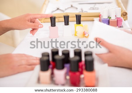 Manicurist working on her client\'s nails at beauty salon.