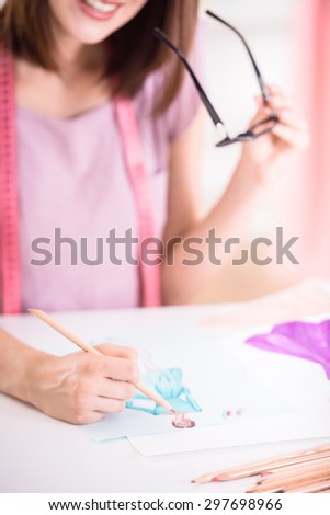 Young female fashion designer drawing sketch and concentrated on her job.