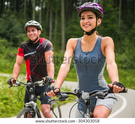 Happy carefree bike couple cycling outdoors and leading healthy lifestyle.