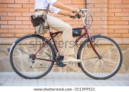 Side view of man is riding bike in the street.