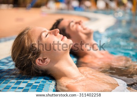 Young couple are relaxing in swimming pool.